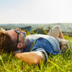 Man lying on grass enjoying peaceful sunny day