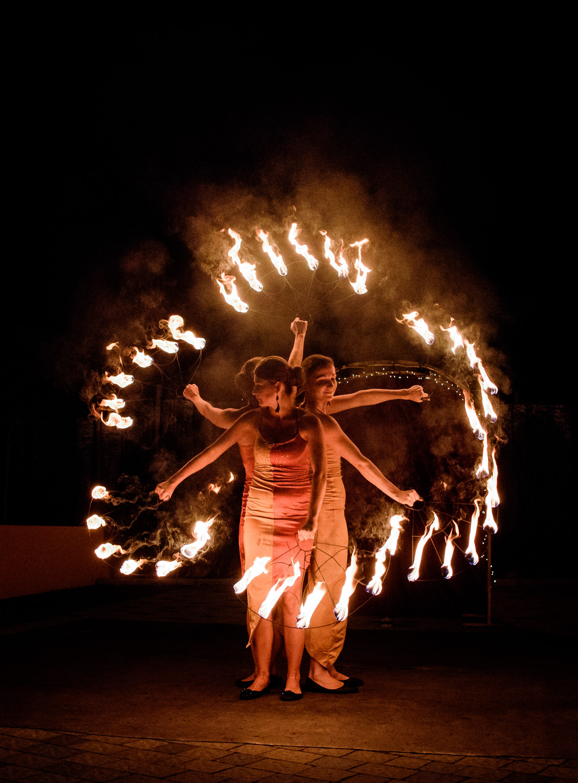 Dancers whirl fire sticks in their hands during the show outside