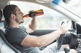 man drinking beer car