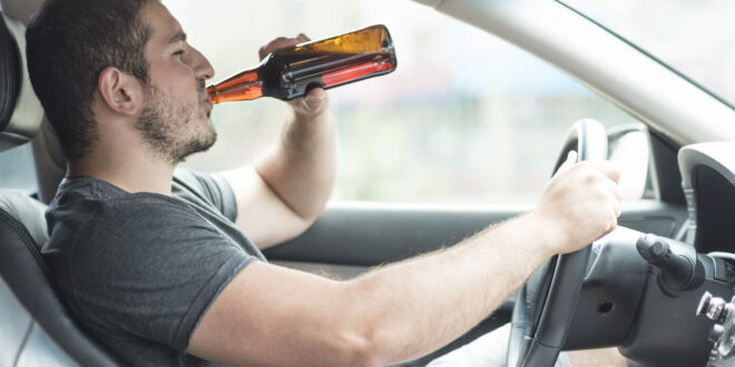 man drinking beer car