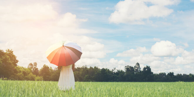 young woman with umbrella meadow