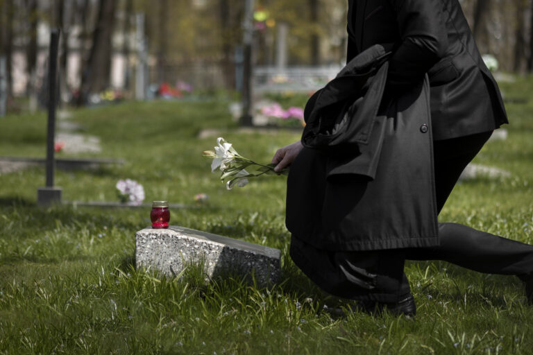 man-paying-respect-tombstone-cemetery