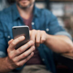Closeup shot of an unrecognizable designer using a cellphone in an office